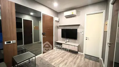 Modern living room with sleek design, featuring wall-mounted TV and air conditioning unit.