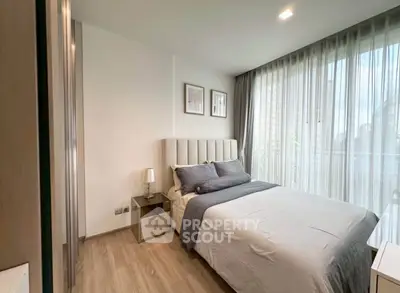 Modern bedroom with large windows and stylish decor in a luxury apartment.