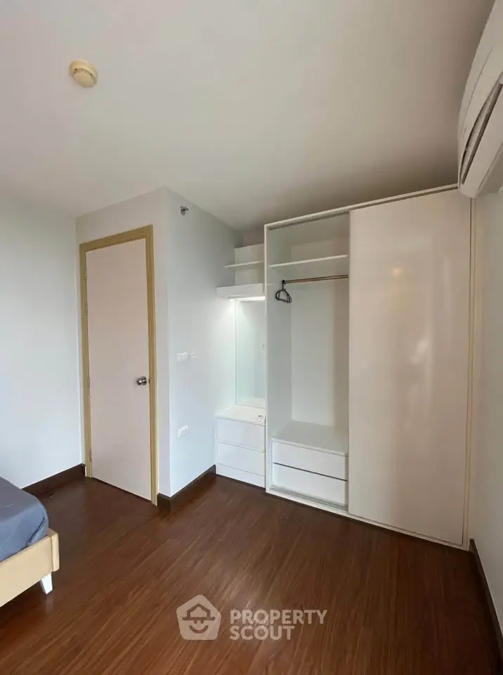 Spacious bedroom with modern wardrobe and wooden flooring