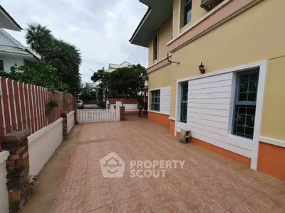 Charming suburban home with spacious driveway and lush greenery.