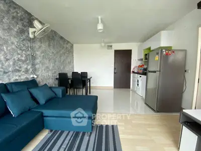 Modern living room with open kitchen, stylish decor, and cozy seating area.