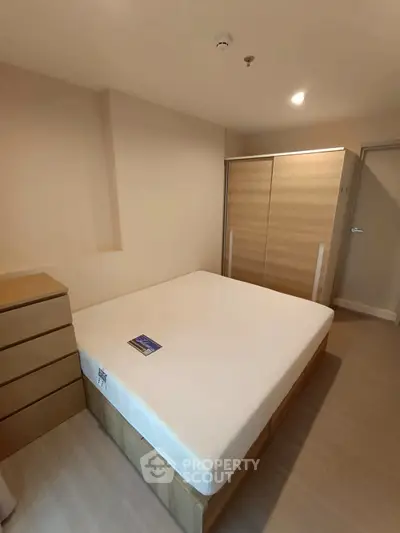 Modern bedroom with minimalist design featuring wooden furniture and spacious wardrobe.