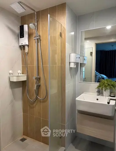 Modern bathroom with sleek shower and stylish sink in contemporary apartment.