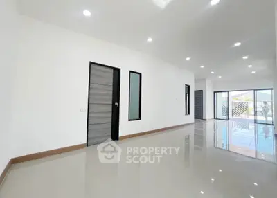 Spacious modern living room with glossy tiled floors and large windows for natural light.