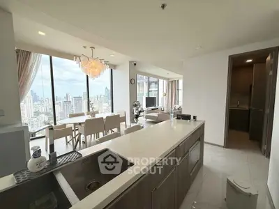 Luxurious open-plan kitchen and living area with stunning city views in modern high-rise apartment.