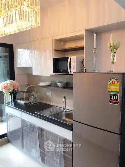 Modern kitchen with sleek design, featuring stainless steel appliances and elegant lighting.