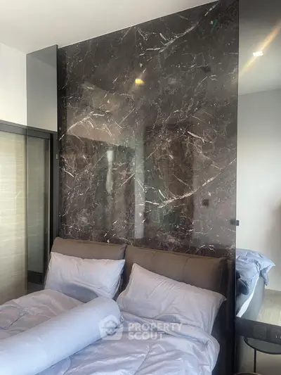 Luxurious bedroom with elegant marble accent wall and plush bedding