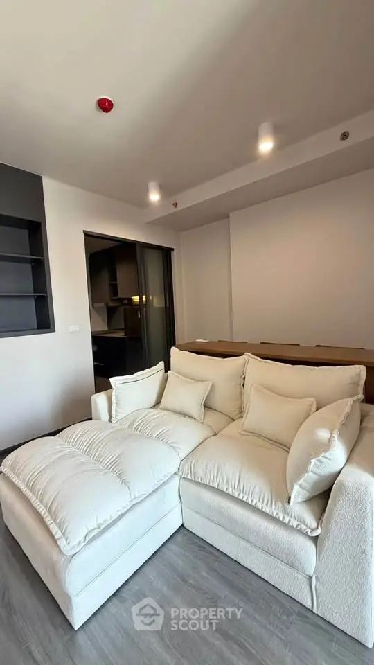 Modern living room with plush white sectional sofa and sleek shelving, perfect for relaxation and entertaining.