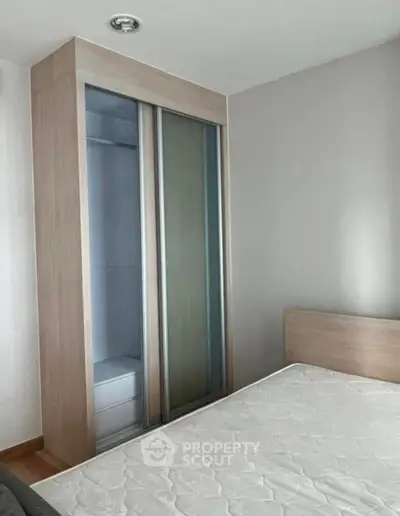 Modern bedroom with sleek wardrobe and comfortable bed in minimalist design.
