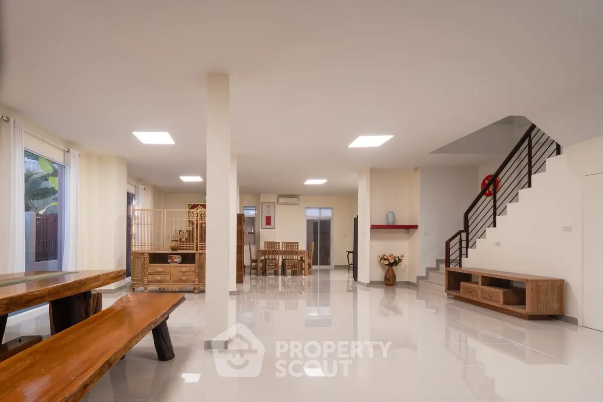 Spacious open-plan living area with modern decor and wooden furniture