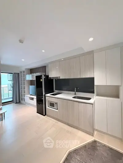 Modern kitchen with sleek cabinetry and appliances in a bright open-plan living space.