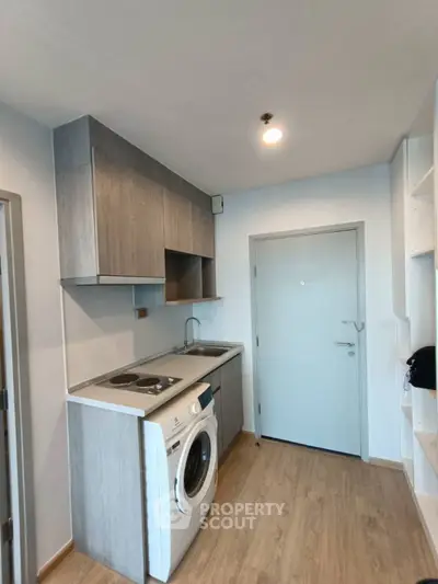 Modern compact kitchen with washing machine and sleek cabinetry