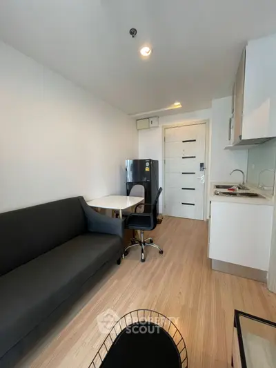 Modern compact studio apartment with sleek kitchen and cozy living area.