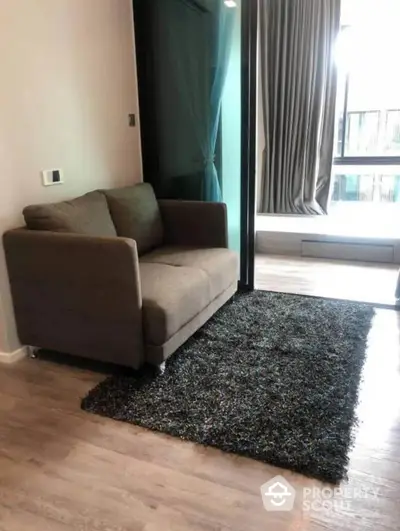 Chic modern living room with plush sofa, shaggy area rug, and sleek hardwood floors, bathed in natural light from large windows.