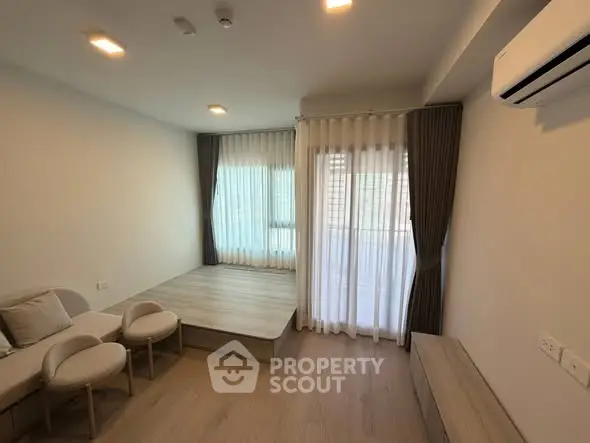 Modern living room with elevated platform and stylish curtains in a cozy apartment.