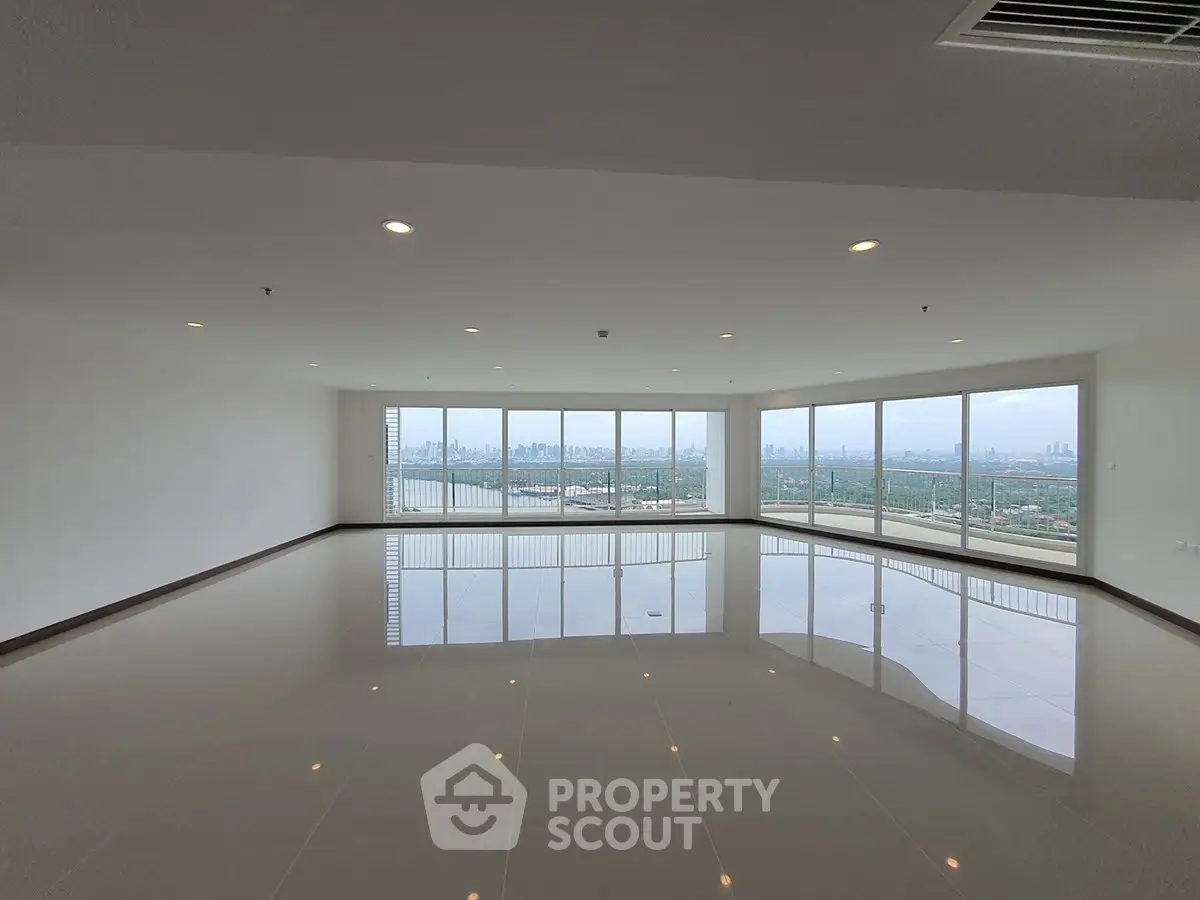 Spacious corner unit with panoramic city views and large windows in a modern high-rise.