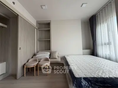 Modern bedroom with minimalist design, featuring a bed, built-in shelves, and large window for natural light.