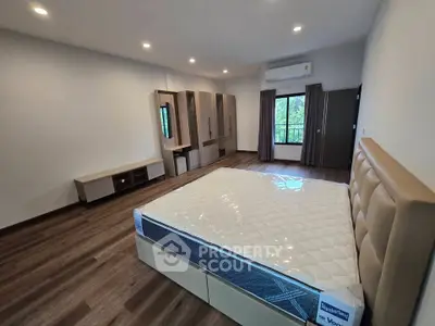 Spacious bedroom with modern furnishings and large window view