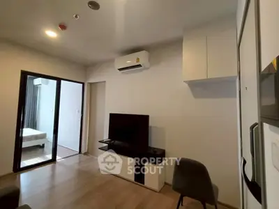 Modern living room with air conditioning and TV, adjacent to a cozy bedroom.
