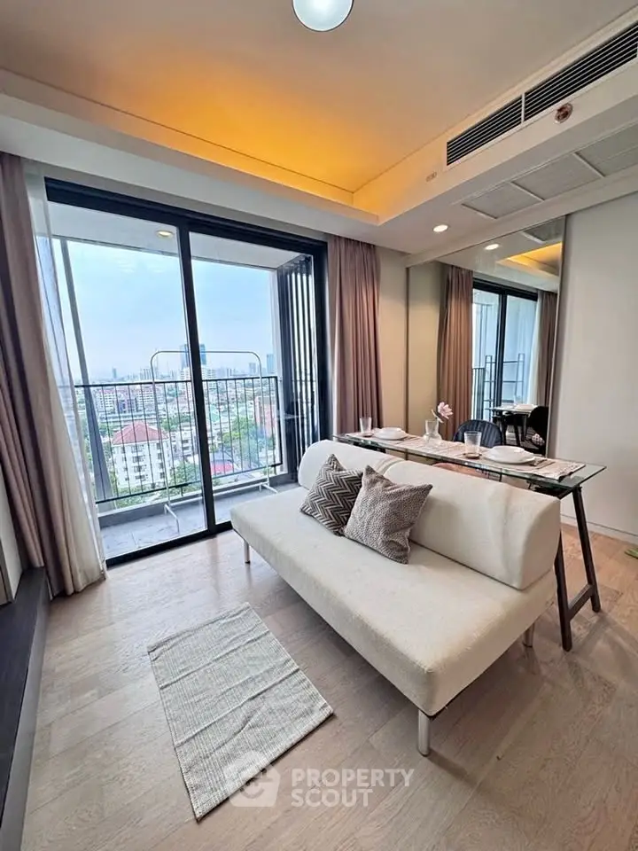 Modern living room with balcony and city view, featuring stylish furniture and elegant decor.