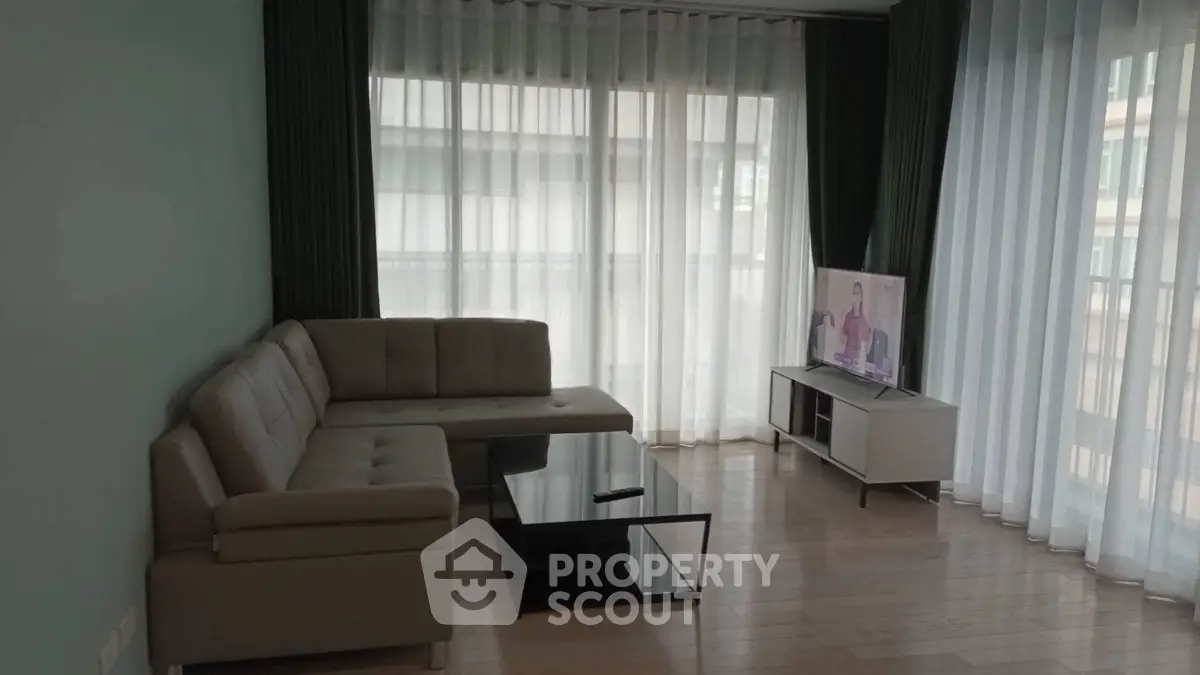Modern living room with sleek furniture and large windows for natural light.