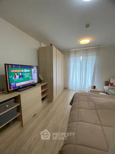 Cozy bedroom with modern decor, featuring a TV and large wardrobe, perfect for relaxation.