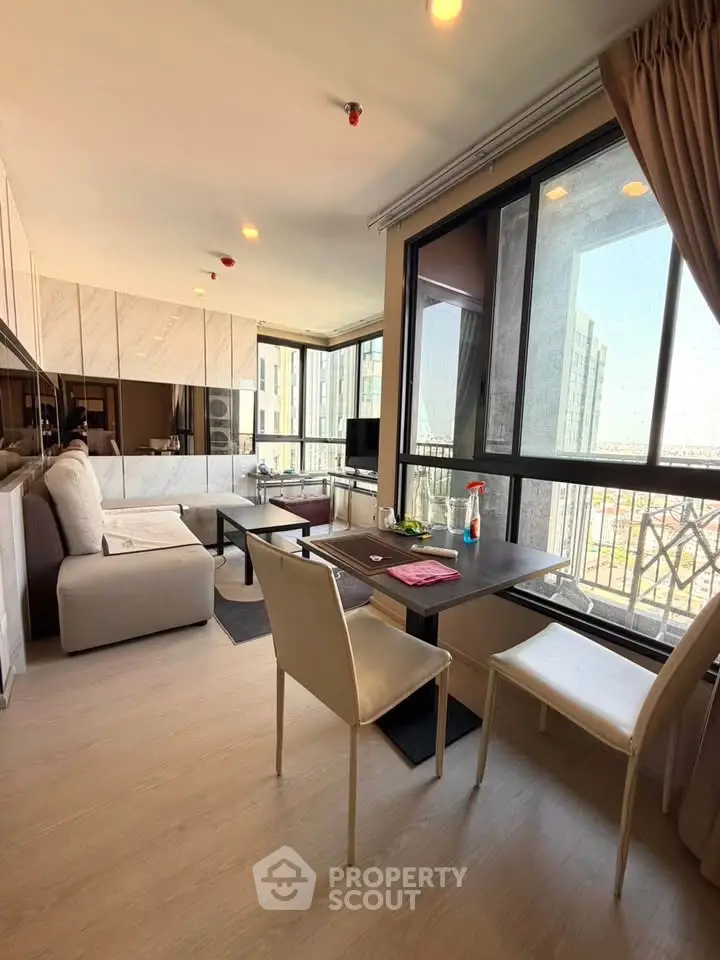 Modern living room with large windows and stylish furniture in a high-rise apartment.