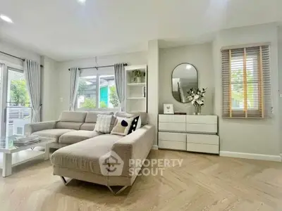 Modern living room with stylish decor and large windows offering natural light and garden view.