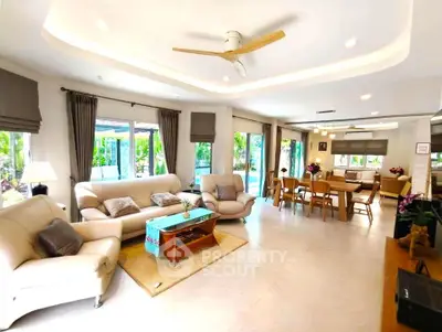 Spacious living room with elegant decor and garden view, perfect for family gatherings.