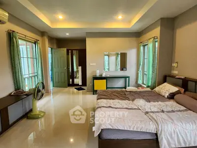Spacious bedroom with modern decor and large windows for natural light.