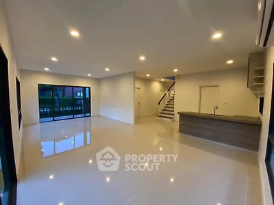 Spacious modern living room with sleek tile flooring and large windows.