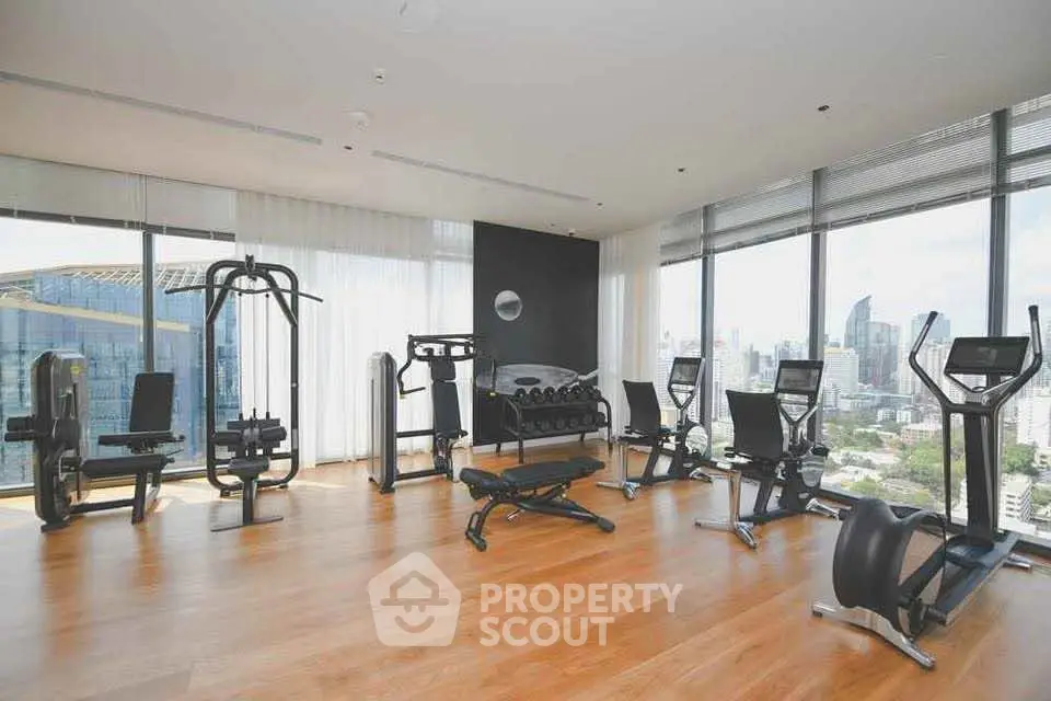 Spacious modern gym with city view in luxury high-rise building