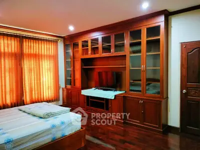 Spacious bedroom with elegant wooden built-in cabinets and cozy lighting.