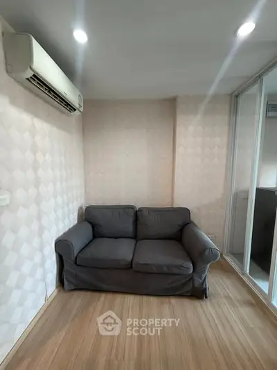 Cozy living room with modern sofa and air conditioning, perfect for relaxation.