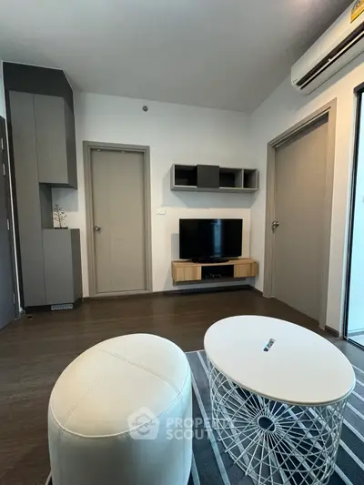 Modern living room with stylish furniture and wall-mounted TV in a cozy apartment.
