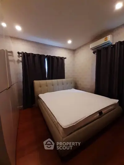 Cozy bedroom with plush bed and modern air conditioning, perfect for restful nights.