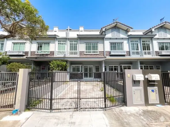 Charming townhouse with gated entrance and modern facade in a serene neighborhood.