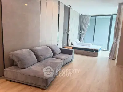 Spacious modern living room with plush sofa and large windows for natural light.