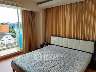 Spacious bedroom with large window and balcony access in modern apartment