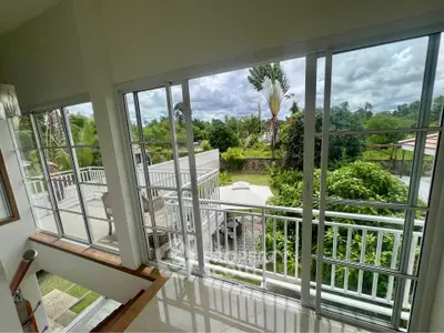 Spacious balcony with lush garden view and large sliding glass doors