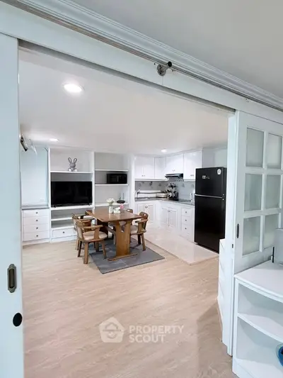 Spacious open-layout kitchen and dining area with modern appliances and elegant wooden flooring.