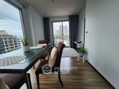Modern living room with city view, stylish furniture, and large windows for natural light.