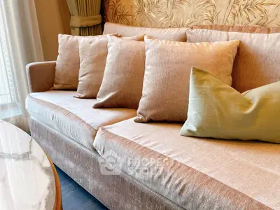 Luxurious living room with elegant beige sofa and plush cushions, perfect for relaxation and style.