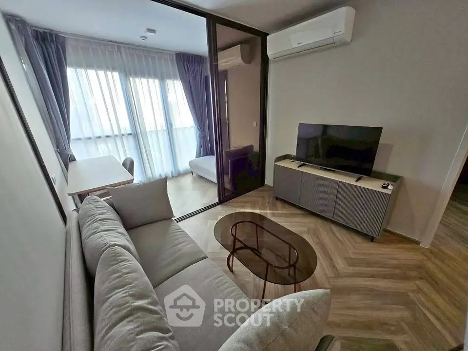 Modern living room with sleek furniture and large window in stylish apartment.