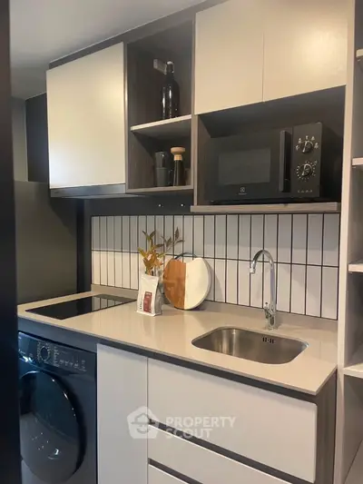 Modern compact kitchen with sleek cabinetry and built-in appliances