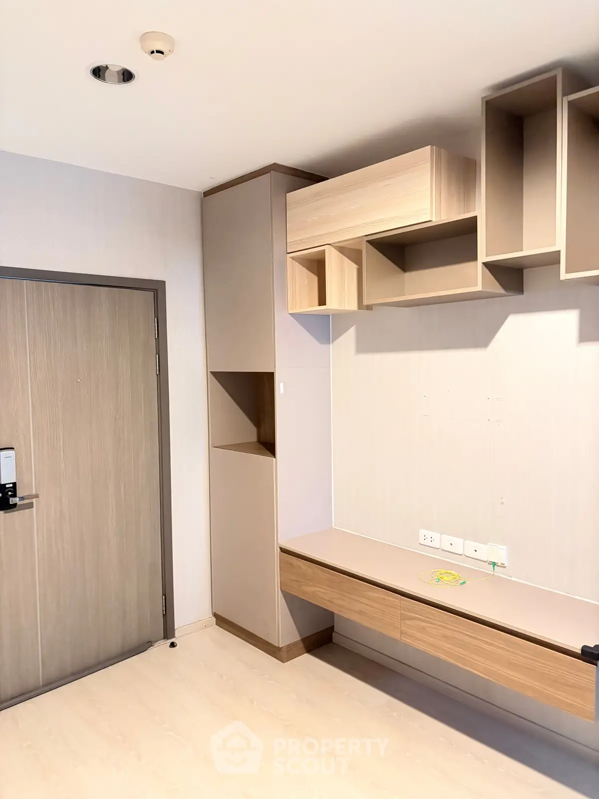 Modern interior with built-in wooden shelves and desk, ideal for a compact study or workspace.