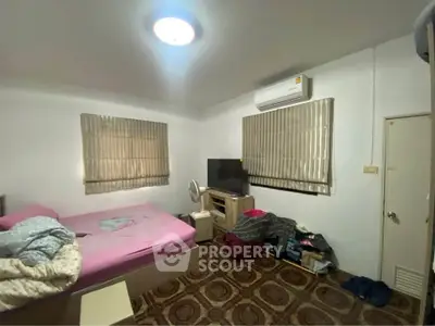 Cozy bedroom with air conditioning and TV, featuring a comfortable bed and stylish flooring.