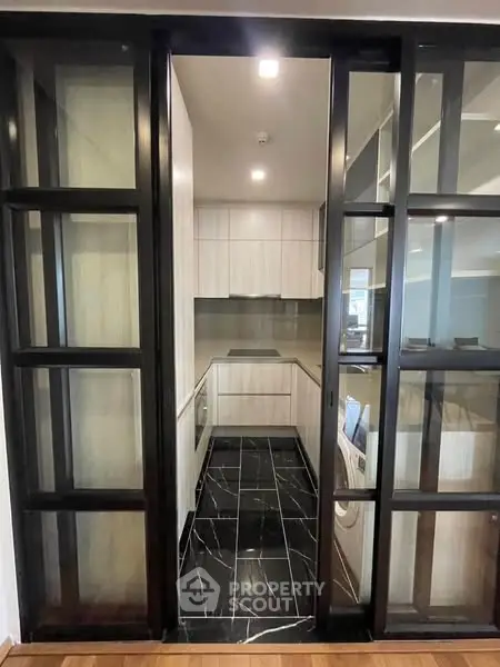 Sleek modern kitchen with glass sliding doors and stylish black flooring