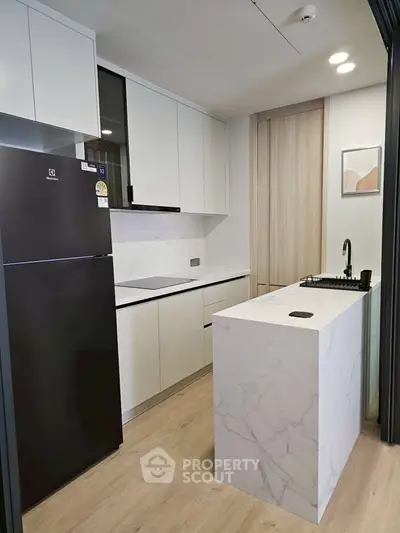 Modern kitchen with sleek white cabinets and marble island