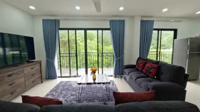 Spacious living room with modern decor and scenic balcony view